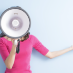 women in a pink shirt speaking through a megaphone
